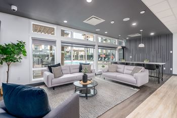 a living room with couches and a table at Vibe Apartments at Arbour Lake in Calgary, AB